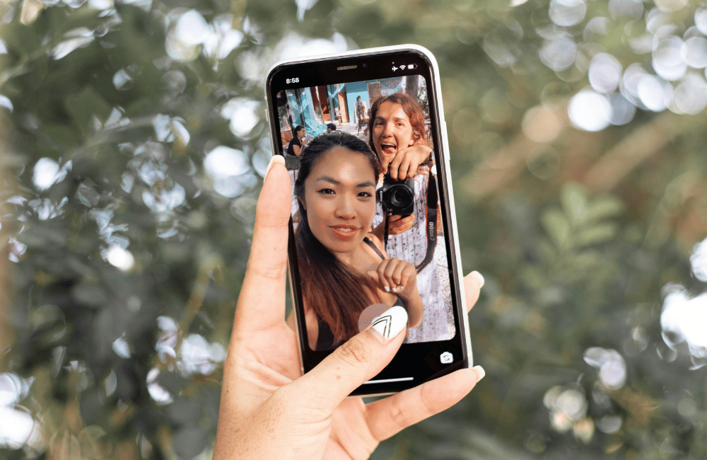 Two women take a selfie, illustrating creating an Instagram Collab Post