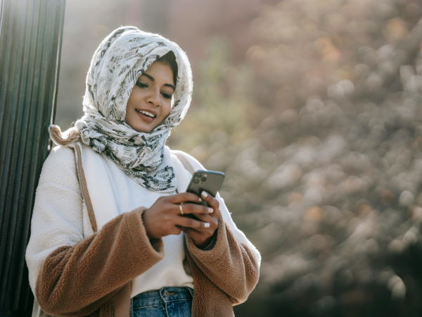 A woman smiles at her phone to illustrate editing a video with Instagram edits