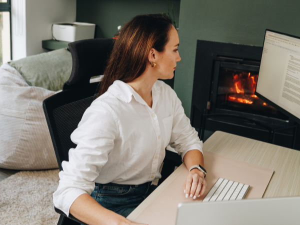 Kirsti Lang sits at her desk reviewing a document on a screen to illustrate finding productivity tools